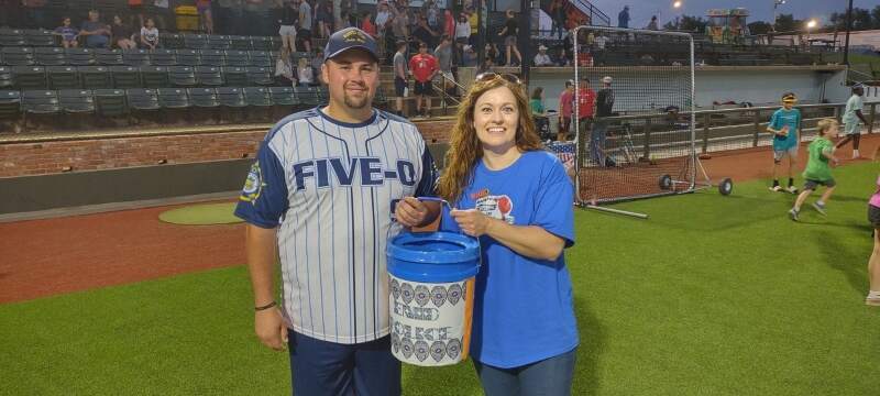 CTB General Sales Manager Jaymi Jander presents donation bucket to Sgt. Tyler Evans.